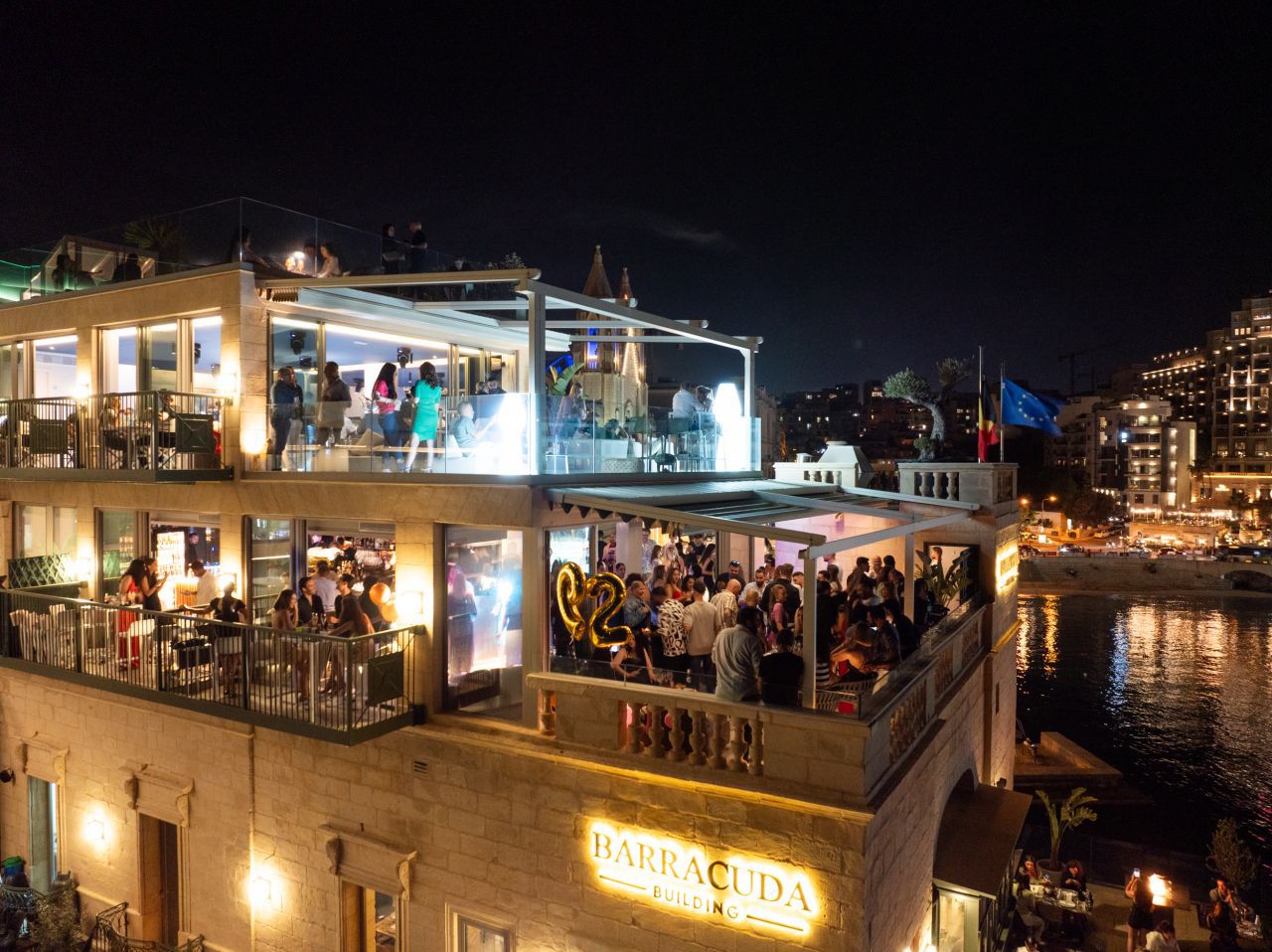 Barracuda Building rooftop venue at night with guests on multiple levels